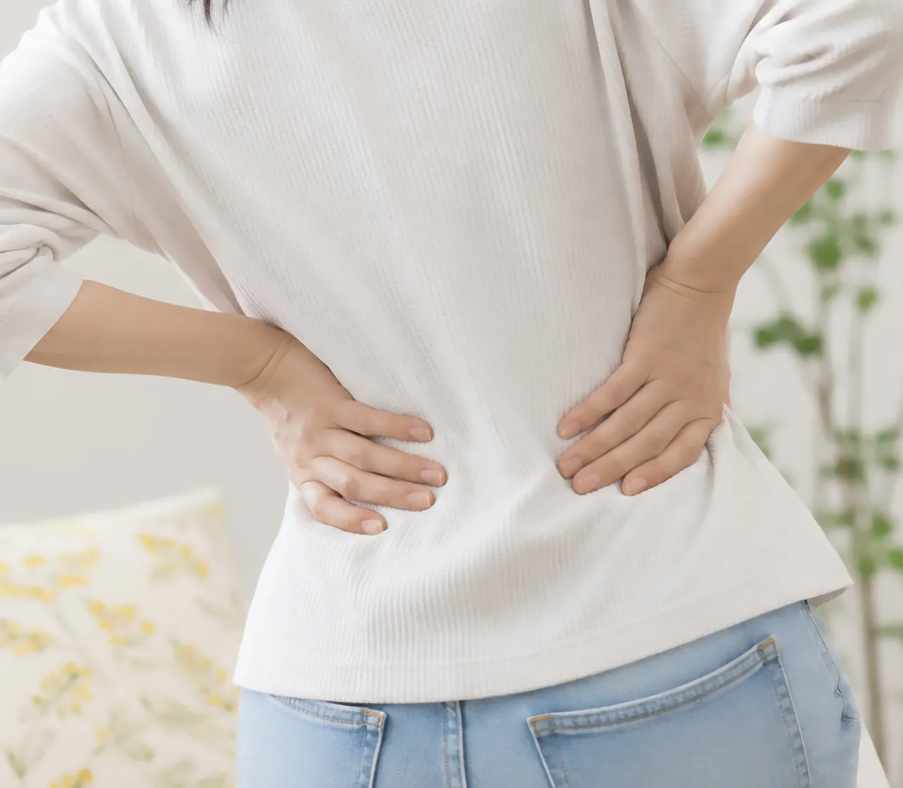 腰に手を添えて痛みを感じている様子